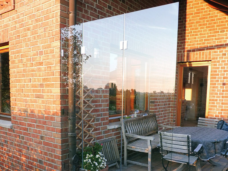 rahmenloser Windschutz auf einer Gartenterrasse